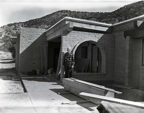 Man standing near entry way to Kolob Canyons Visitor Center during its construction.