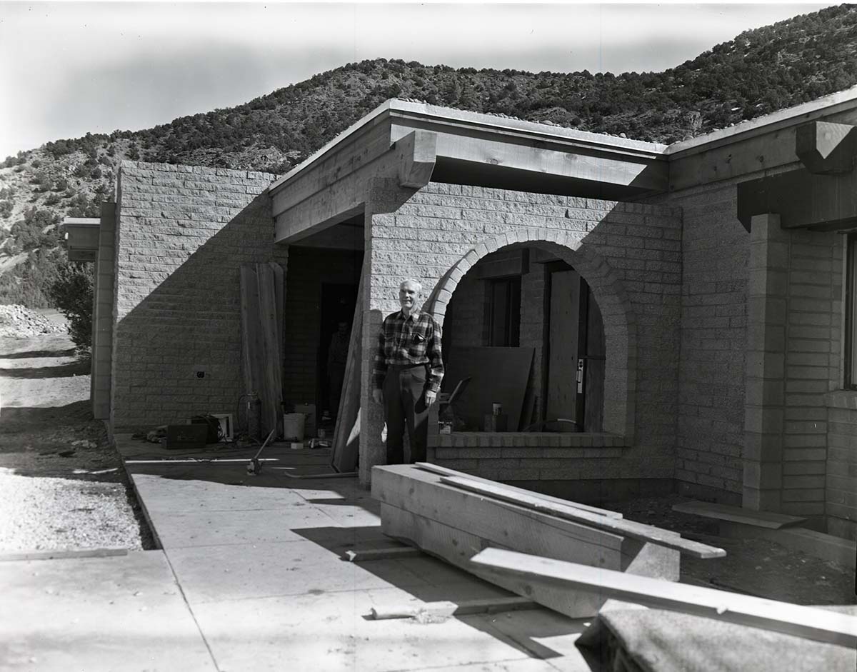 Man standing near entry way to Kolob Canyons Visitor Center during its construction.