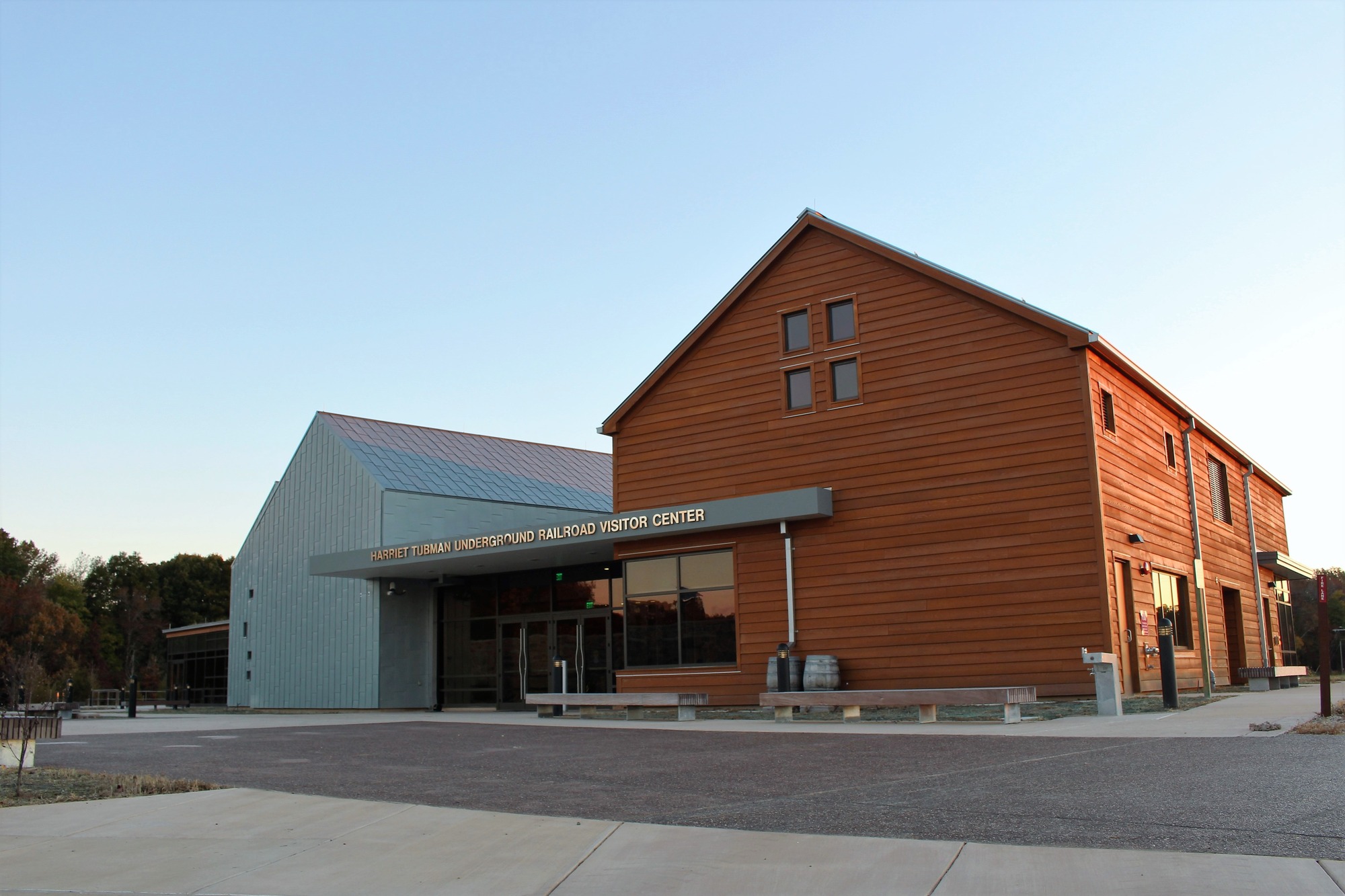 A large building comprised of a wooden barn structure and a metal structure.