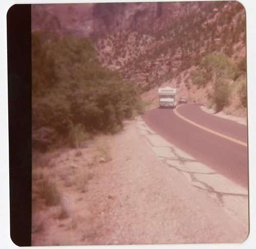 Vehicles driving on road during chipsealing of Zion roads.