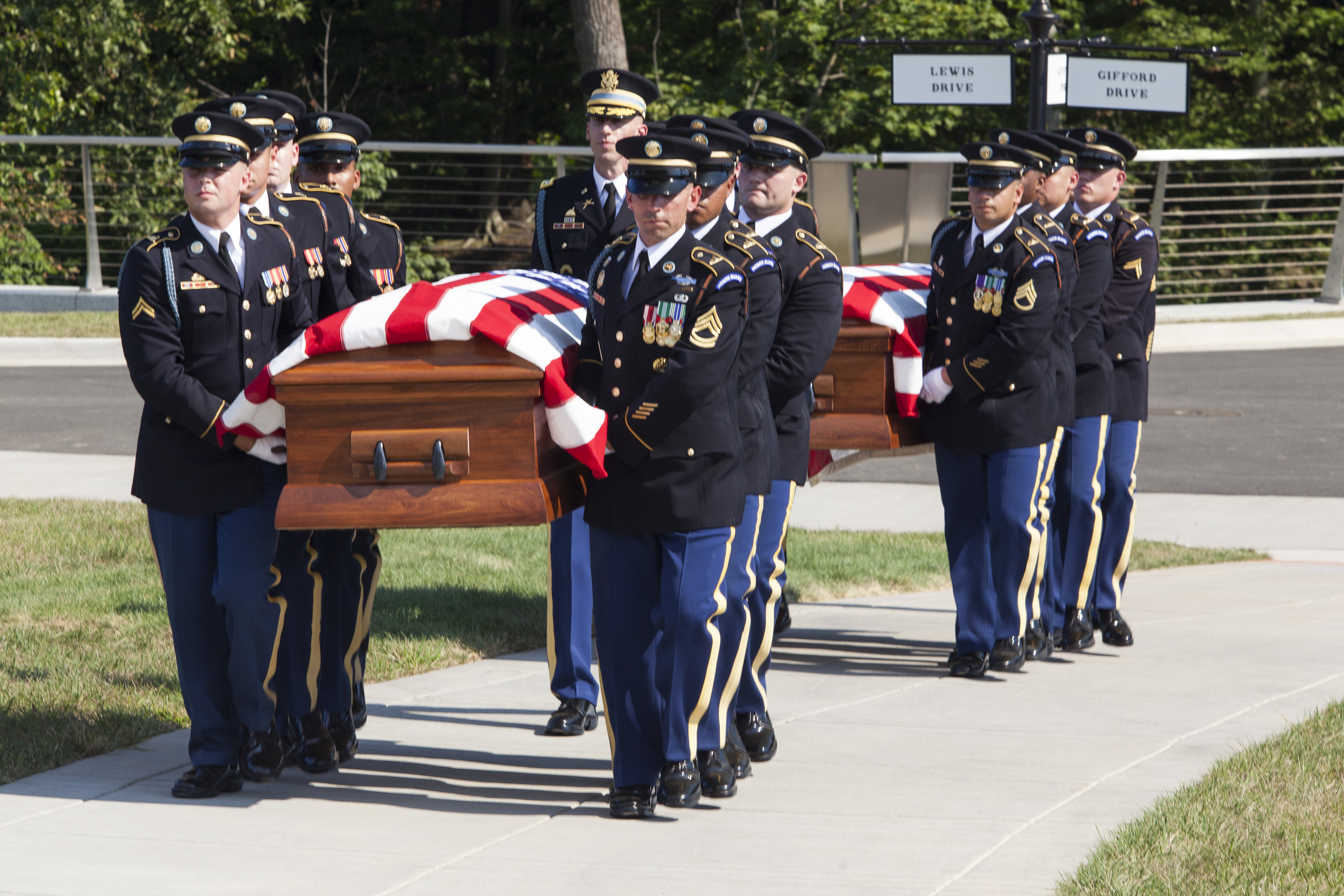 Members of the Old Guard carry two flag covered coffins towards the interment site at Arlington National Cemetery.
