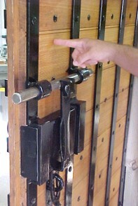 Person's finger pointing at wooden door.