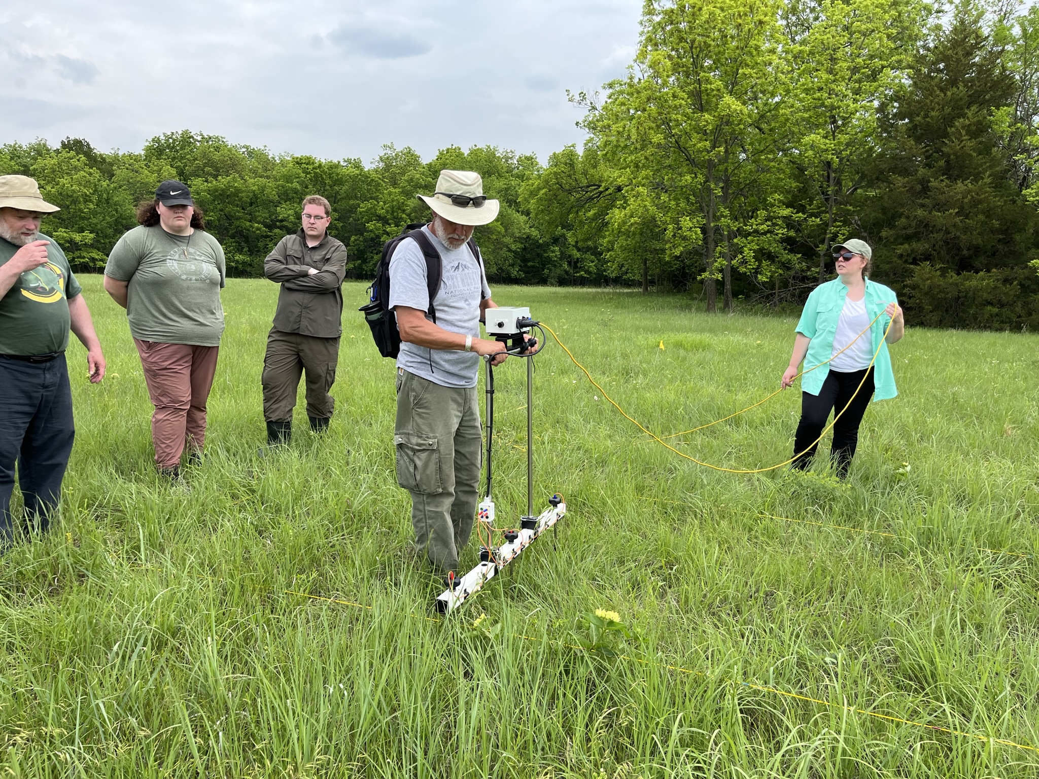 a group of people operating equipment in a field.