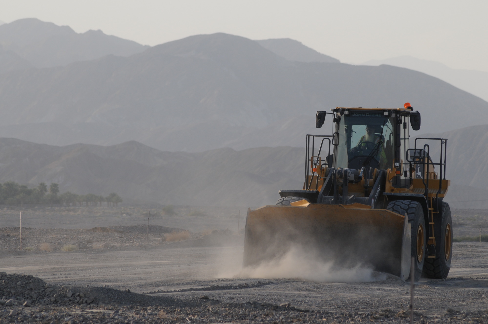 a large tractor moving gravel in a desert canyon