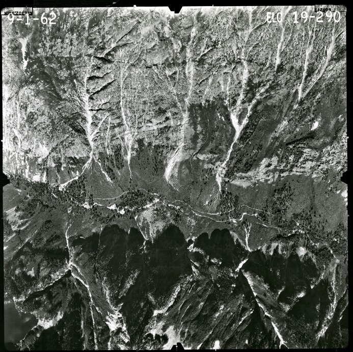 Black and white aerial photograph of glaciated mountain peaks and valleys.