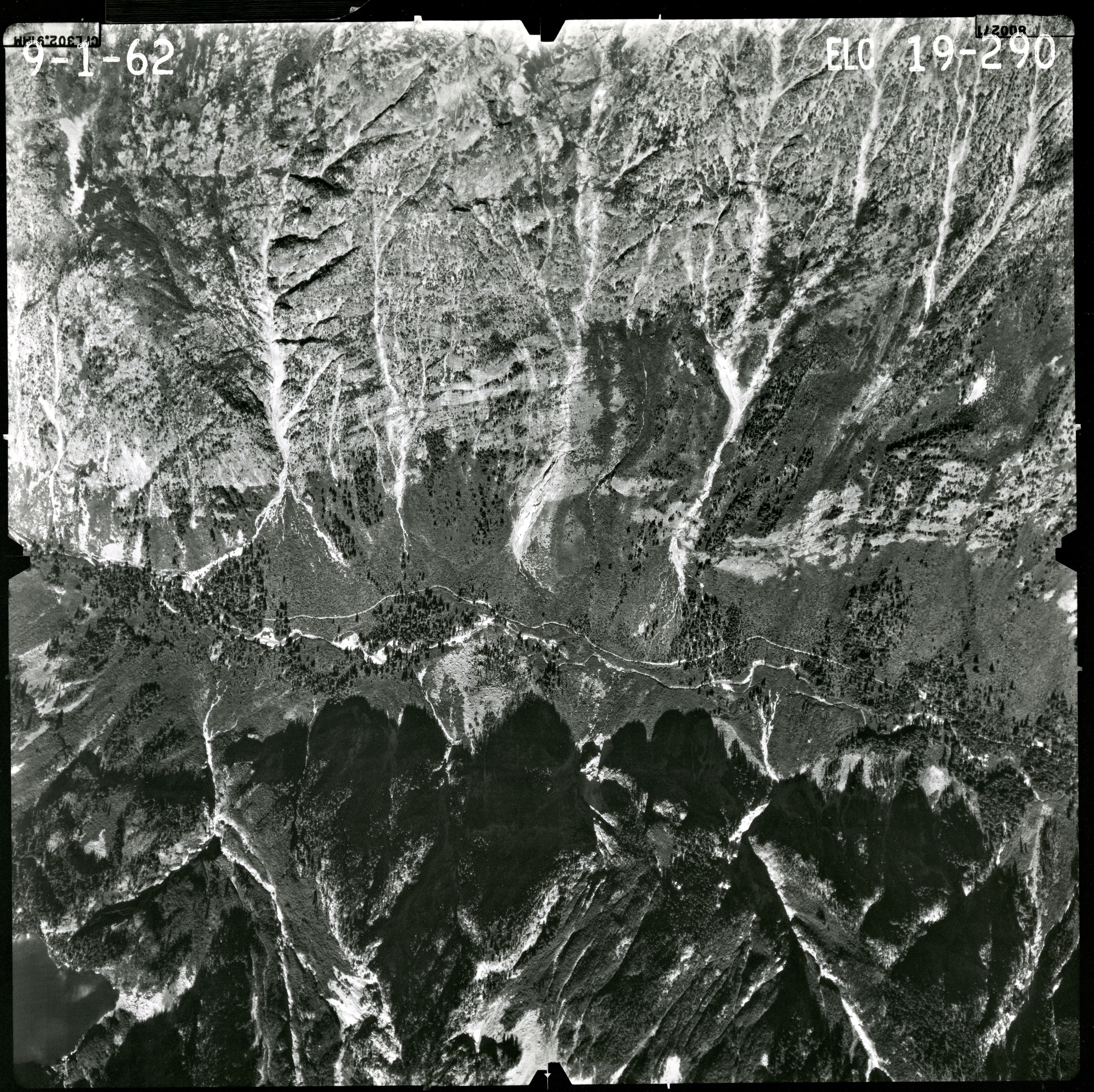 Black and white aerial photograph of glaciated mountain peaks and valleys.