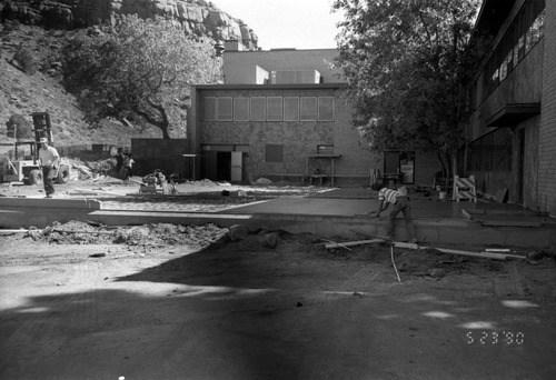 Men leveling concrete during the construction of headquarters addition.