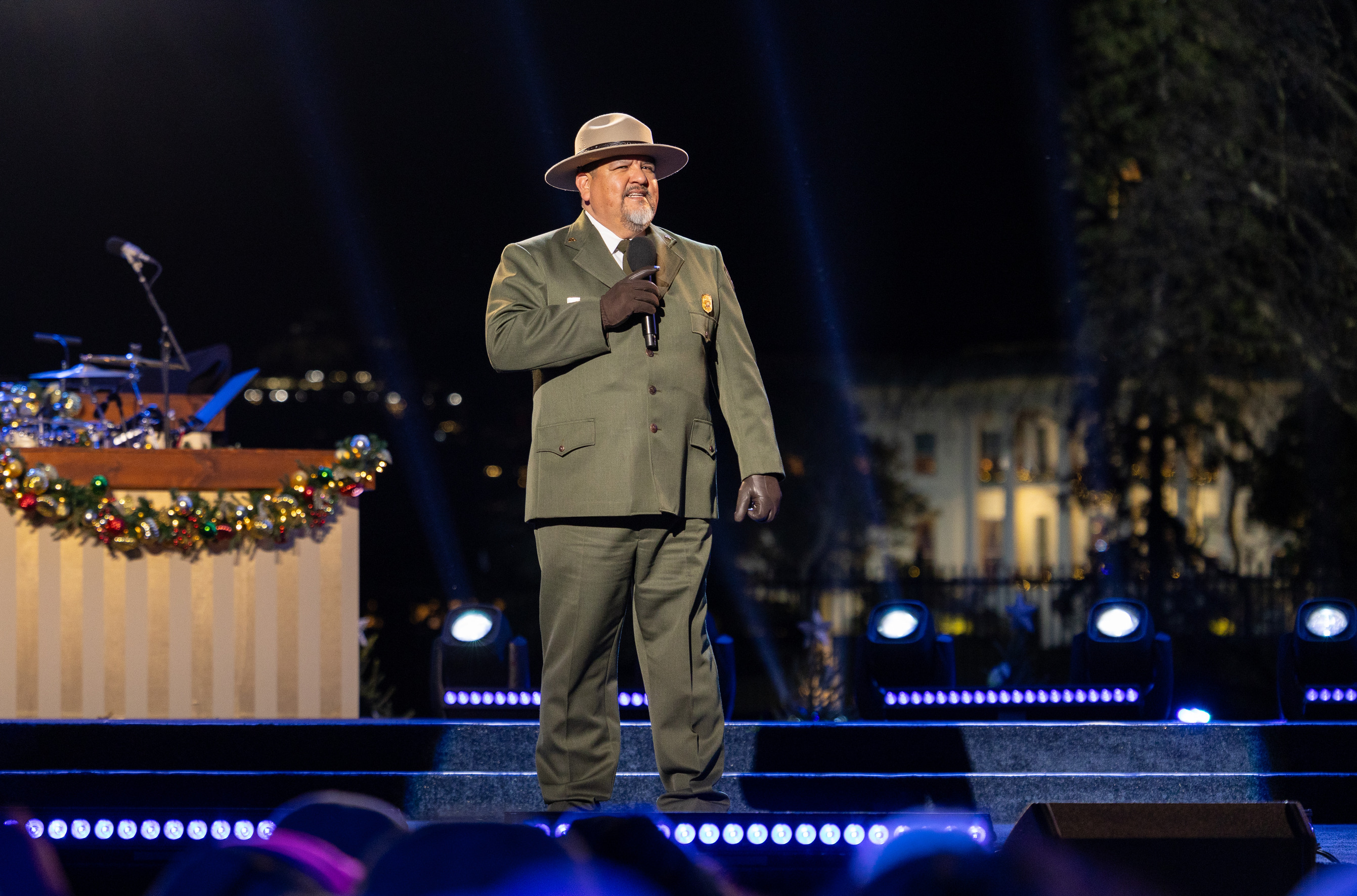 The Director of the Park Service stands on a stage with the White House in the distance