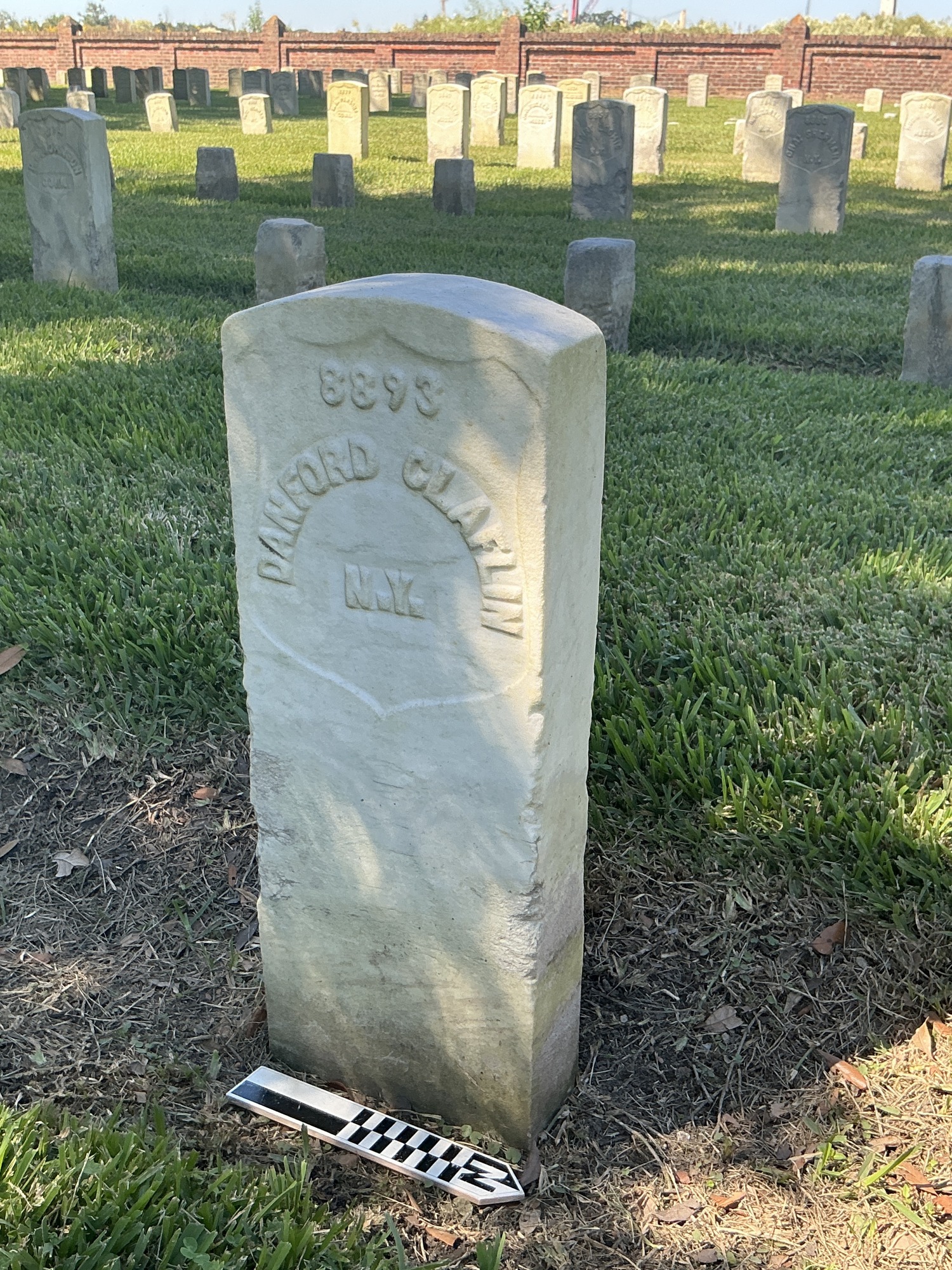 Extra image of historic upright marble headstone with recessed shield with recessed lettering face.