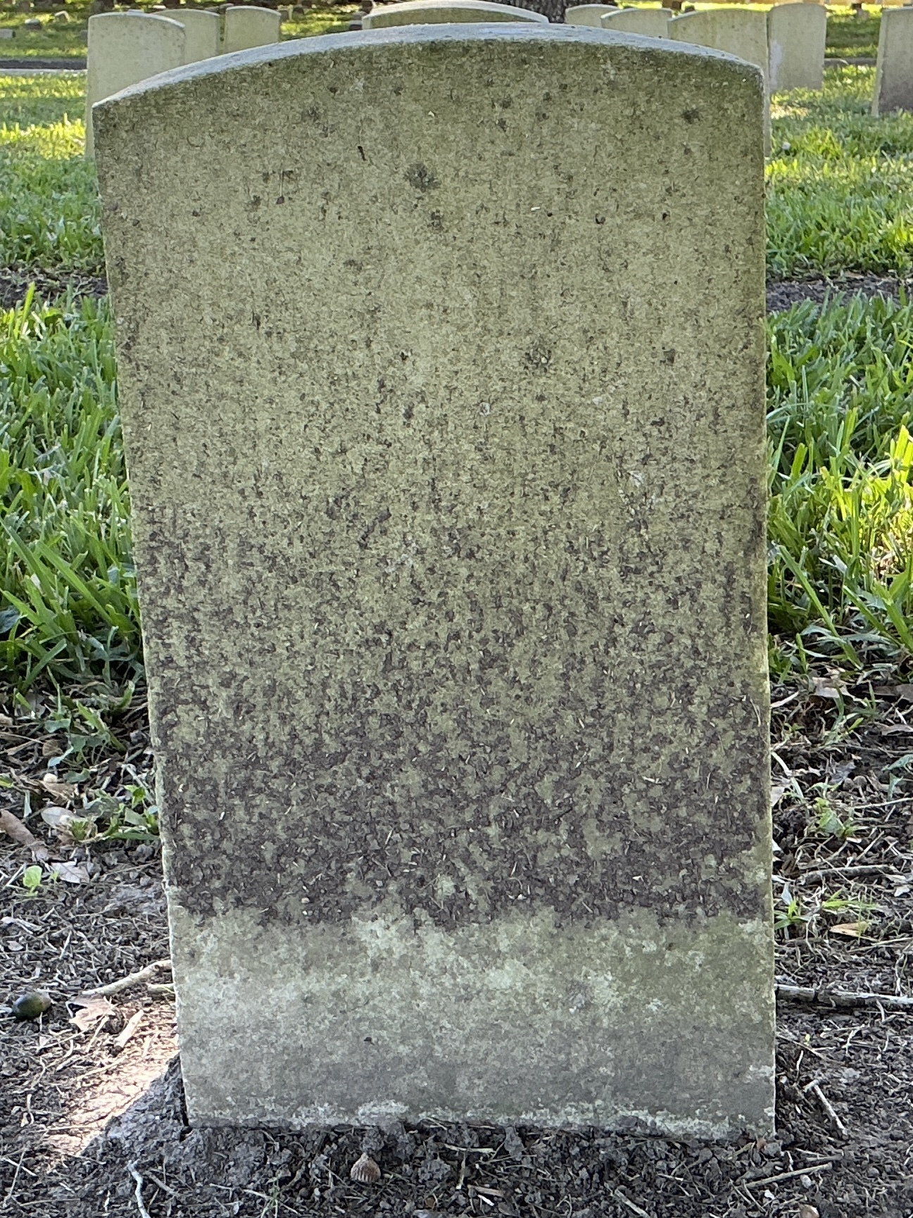 Back of historic upright marble headstone with recessed shield face.
