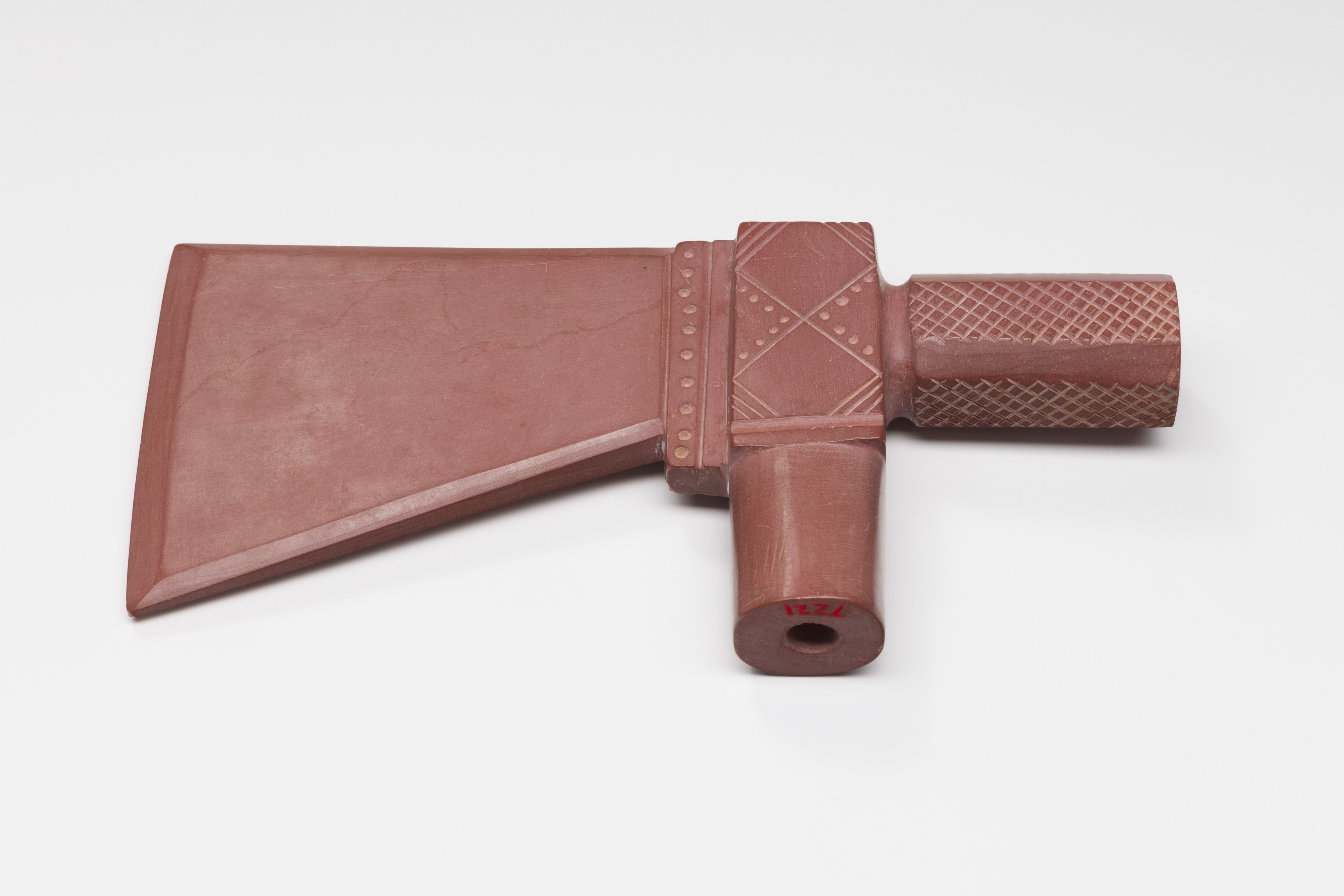 Red stone pipe head in form of a hatchet.