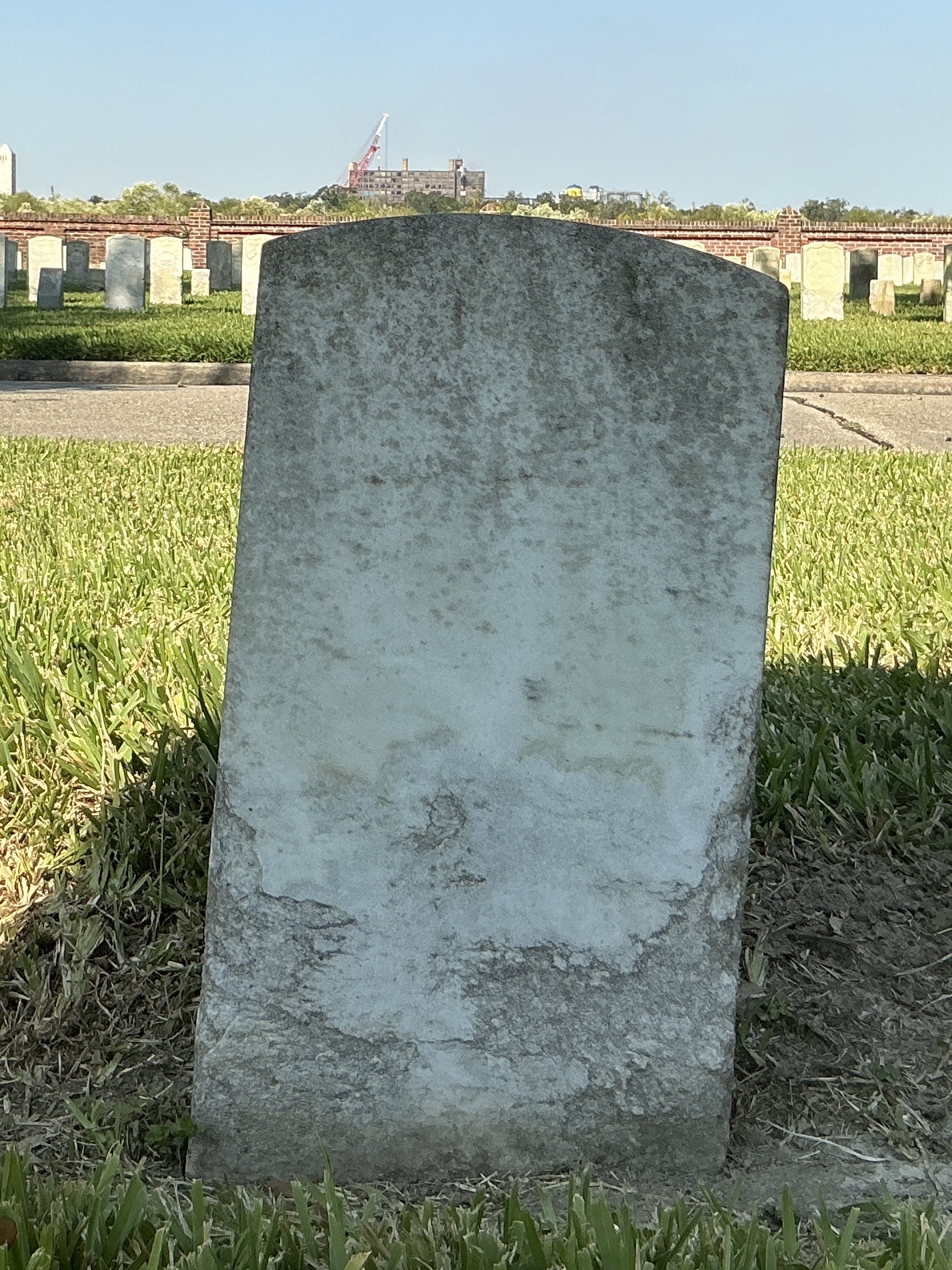 Back of historic upright marble headstone with recessed shield with recessed lettering face.