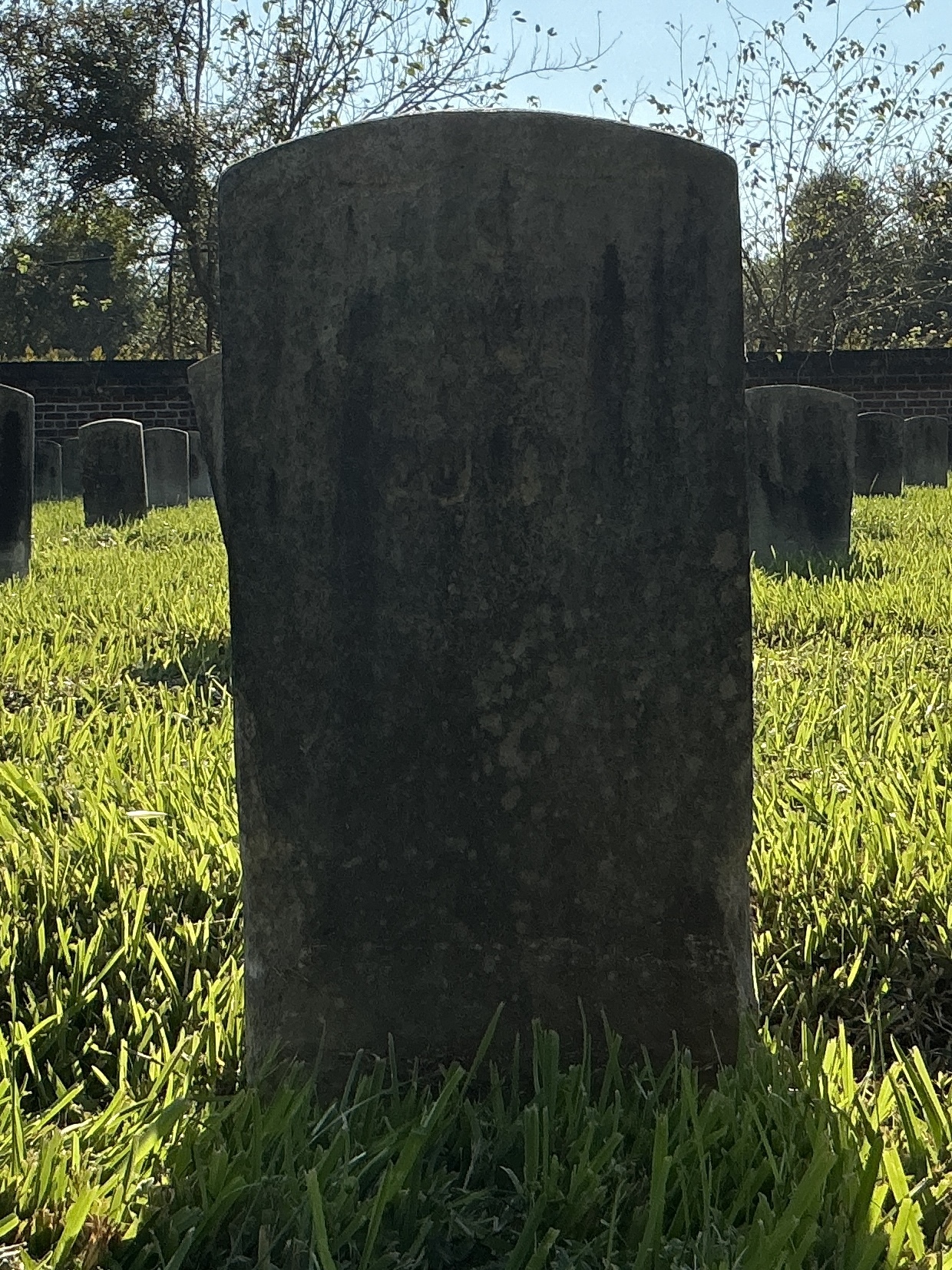 Front of historic upright marble headstone with recessed shield face.