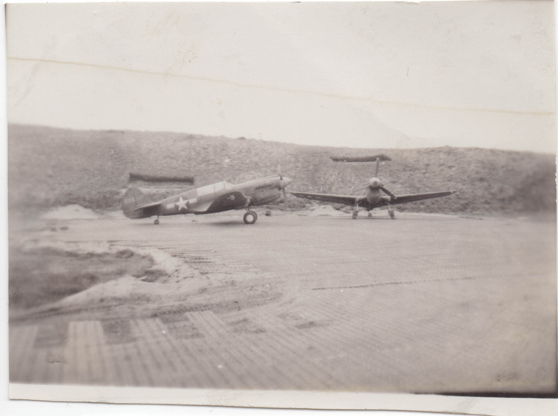 Two planes in front of an earth embankment