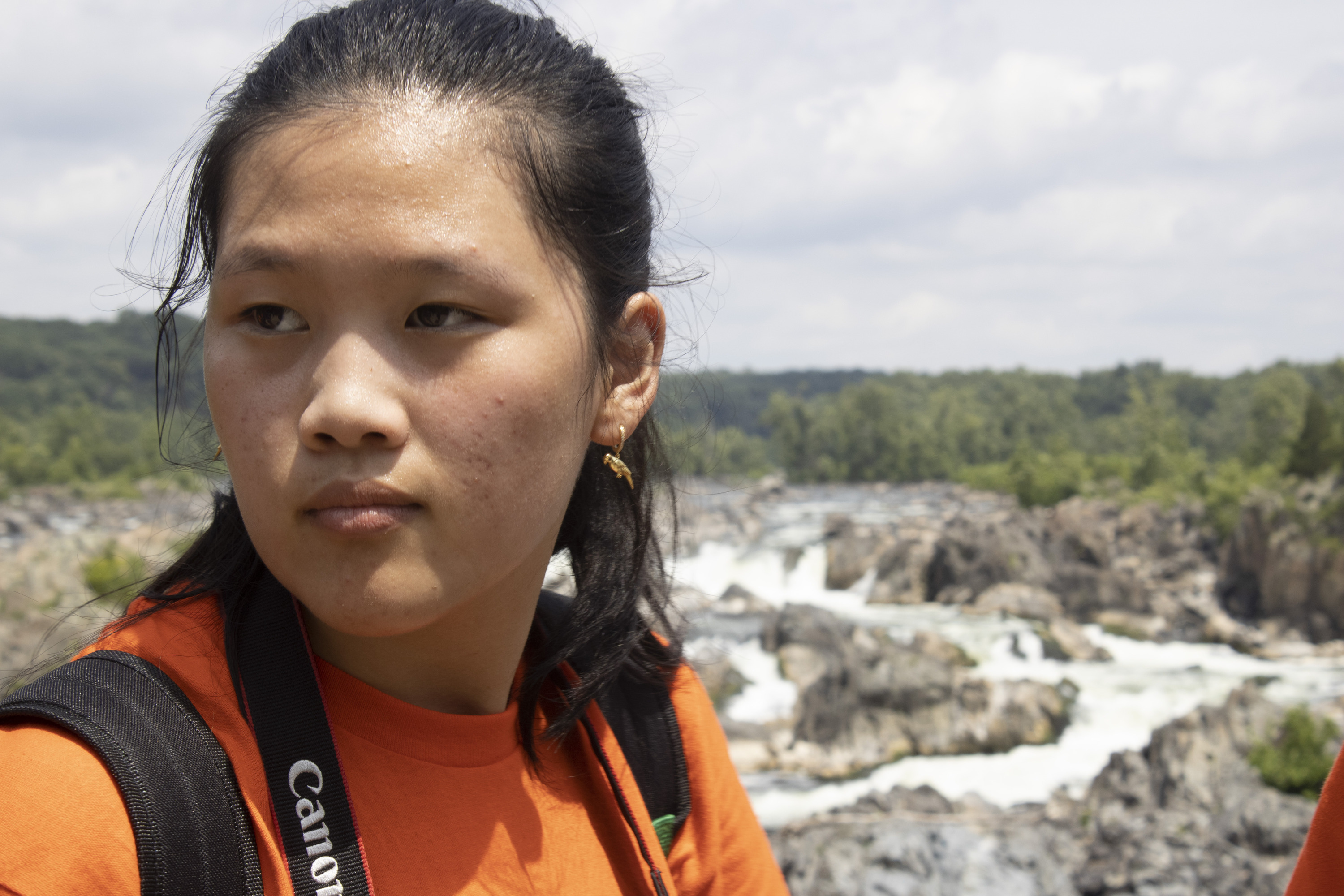 President's Park student volunteer,  Audrey Saenz gazing to the right, with the Potomac river in the background at Great Falls Park.