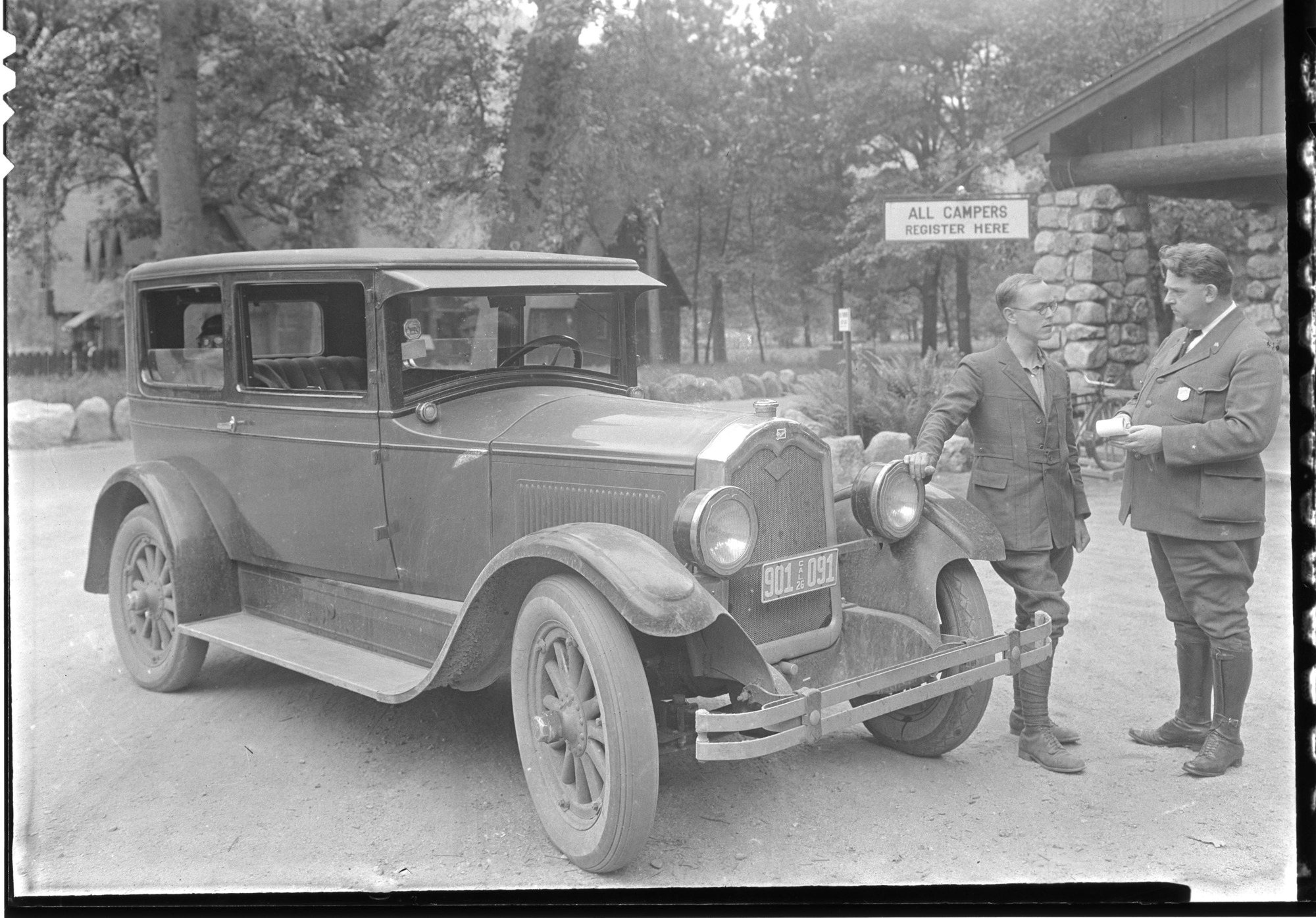 Ranger E. R. Reed questioning a visitor as to road conditions.