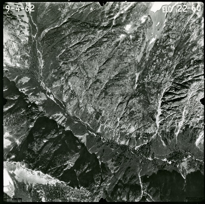 Black and white aerial photograph of glaciated mountain peaks and valleys.