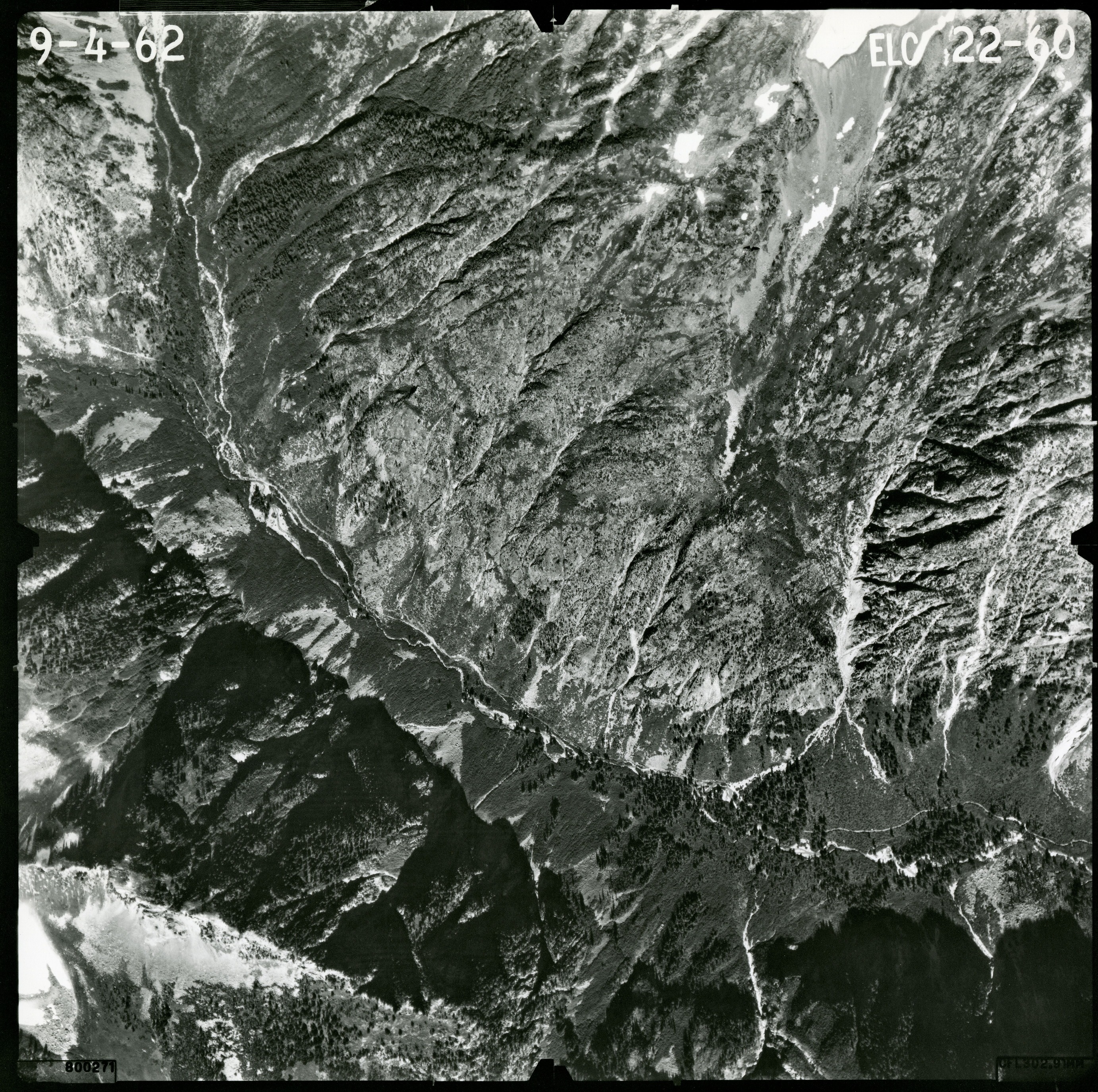 Black and white aerial photograph of glaciated mountain peaks and valleys.