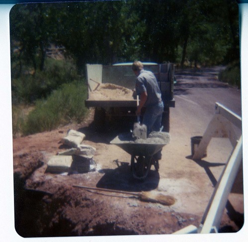 Man filling wheelbarrow with construction materials for the construction of the Springdale water pipeline.