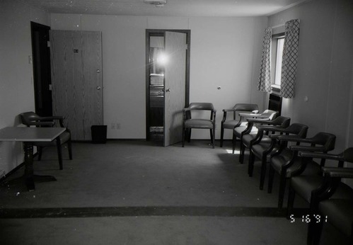 Chairs along wall of living room area in barracks. [Image possibly for comparative housing study]