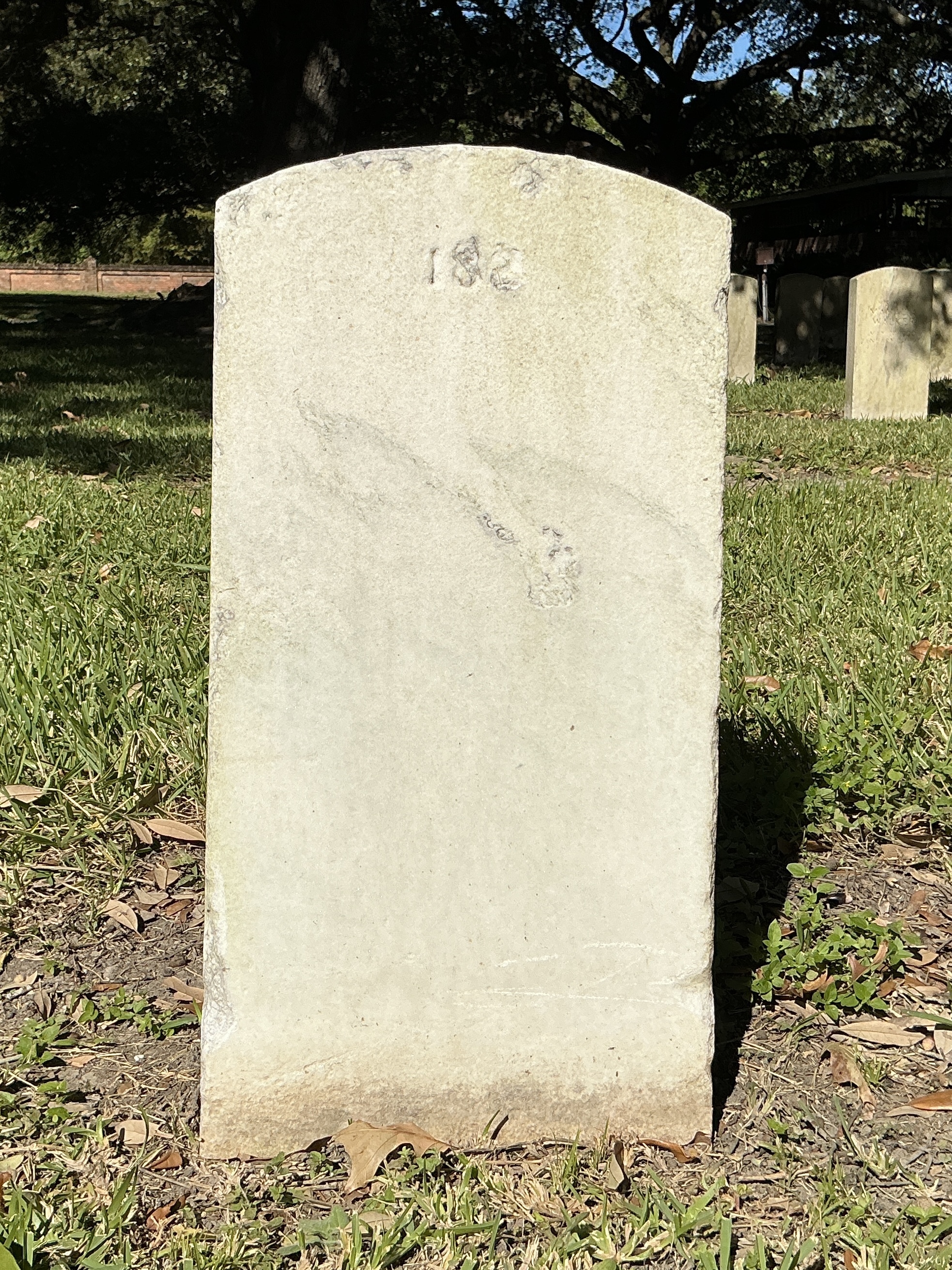 Back of upright marble headstone with flat face.