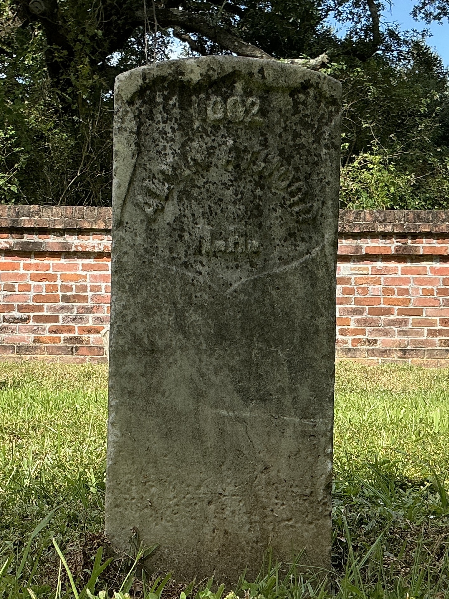 Front of historic upright marble headstone with recessed shield face.