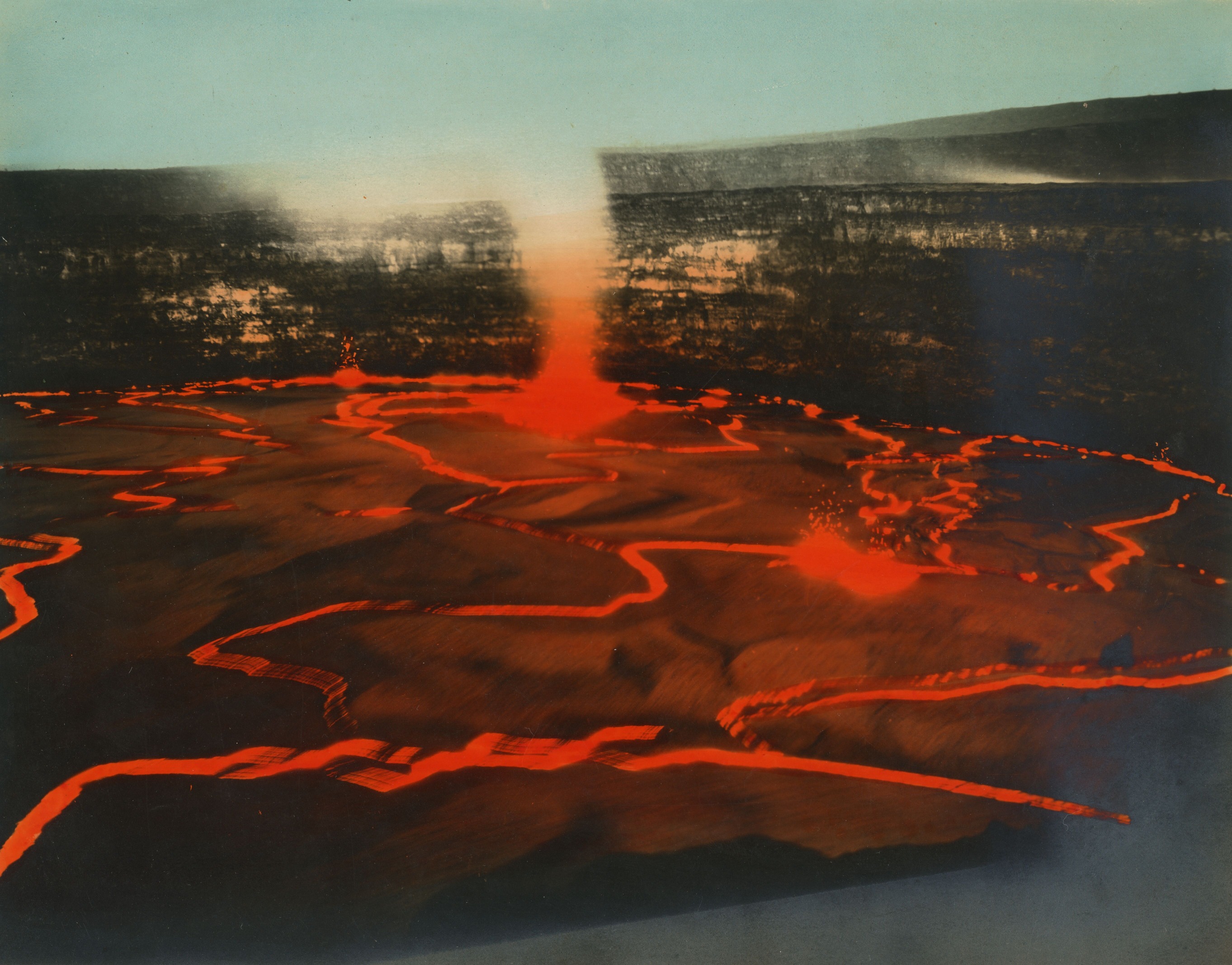 Hand-colored photograph of a field of molten lava. Originally a black and white photograph, the image has been colorized post-capture with bright red and light blue. The entire forefront of the image consists of a dynamic lava flow, as evidenced by areas of lava spewing vertically. Large areas of dried lava sit atop the molten lava below and form rough cracks that have been colorized with bright-red paint. Towards the background, a lava fountain breaks through the cracks and releases a cloud of steam. The lava field sits within the edges of a crater which takes up almost the entirety of the background. The top half of the photograph is sky which has been colorized with light-blue paint.