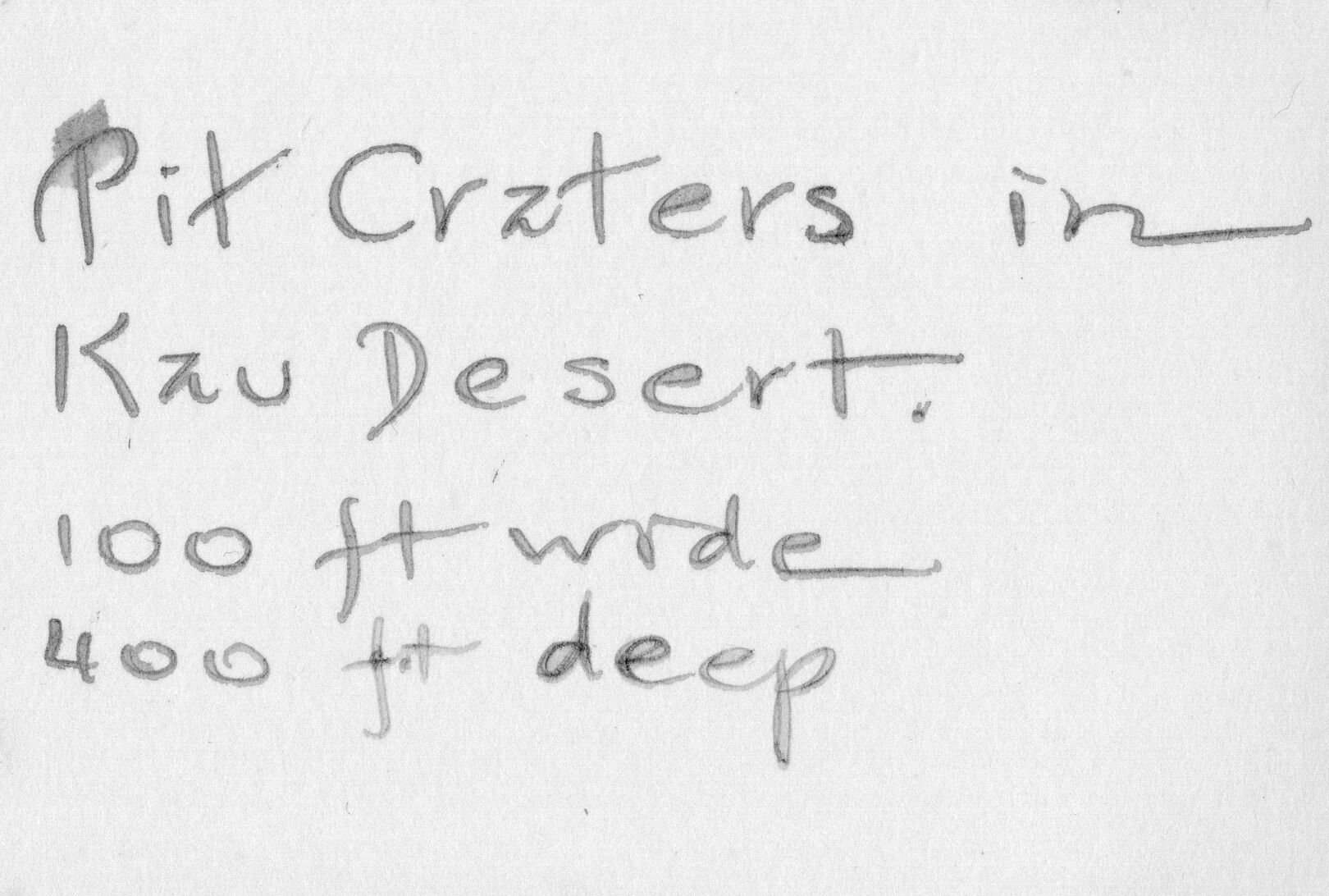 The backside of an image of two pit craters in the Kaʻu desert. In the center of the image there is a caption, "Pit Craters in Kaʻu Desert. 100 ft wide 400 ft deep."