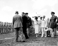 HPC-000662. Left to right: back to camera, Robert Feckner, Director of the CCC (Civilian Conservation Corps), His Royal Highness King George VI, unknown, Her Royal Highness Queen Elizabeth, Eleanor Roosevelt, Mackenzie King, Prime Minister of Canada, A. E. Demaray, NPS, unknown, touring CCC camp (Fort Hunt). George Washington Memorial Parkway.