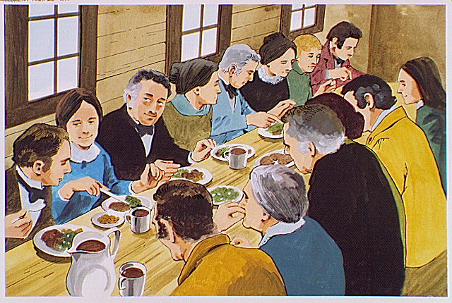 Crowded quarters below deck of a canal boat at mealtime.