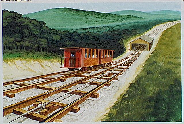 Inclined plane with shed showing rail-cars on tracks.