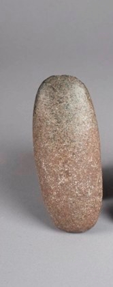 Pitted grey, black, and white stone tool