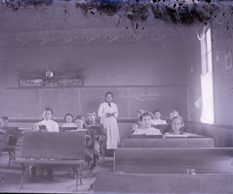 Teacher and students in 1910 school room