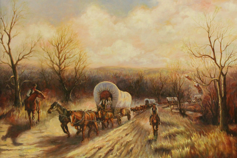 Covered wagons are pulled by horses along a trail