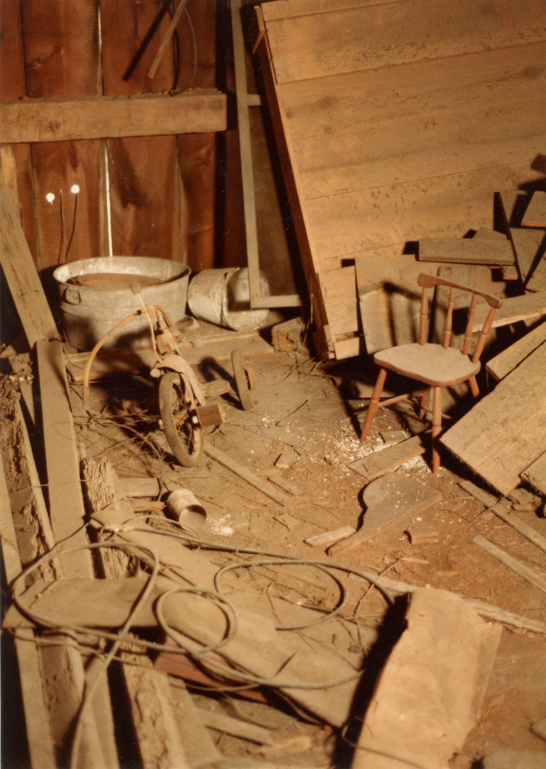 east wall of loft with wooden debris and wooden furniture specifically tricycle, chair and washtub