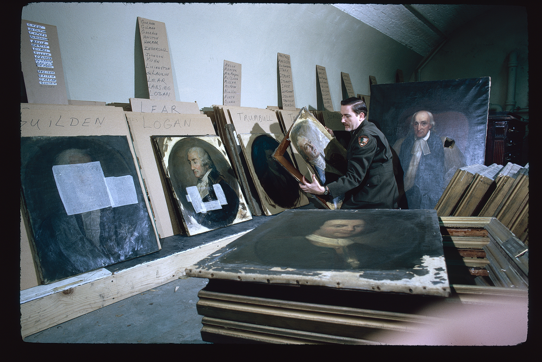 Second Bank of the United States. Interior. Basement. Park service worker organizing portraits requiring restoration.