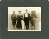 Four People Beside Markers on the Little Bighorn Battlefield