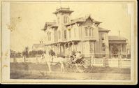 Man and a Woman in a Small Carriage in Front of an Elaborate Home in Oneonta, New York
