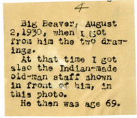 Big Beaver Seated in Front of a Tent Holding Two Pieces of His Artwork