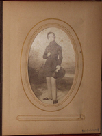 Faded black and white photograph of painting of young man outside.