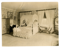 Black and white photograph of 19th century guest room featuring empire style furniture.