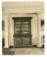 Black and white photograph of Renaissance revival book cases between Greek columns.