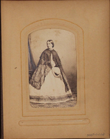 Black and white photograph of woman holding hat.