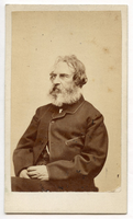 Bearded Henry Wadsworth Longfellow with graying hair is seated facing three quarters to viewer's left. His hands are folded in his lap. His coat is trimmed.