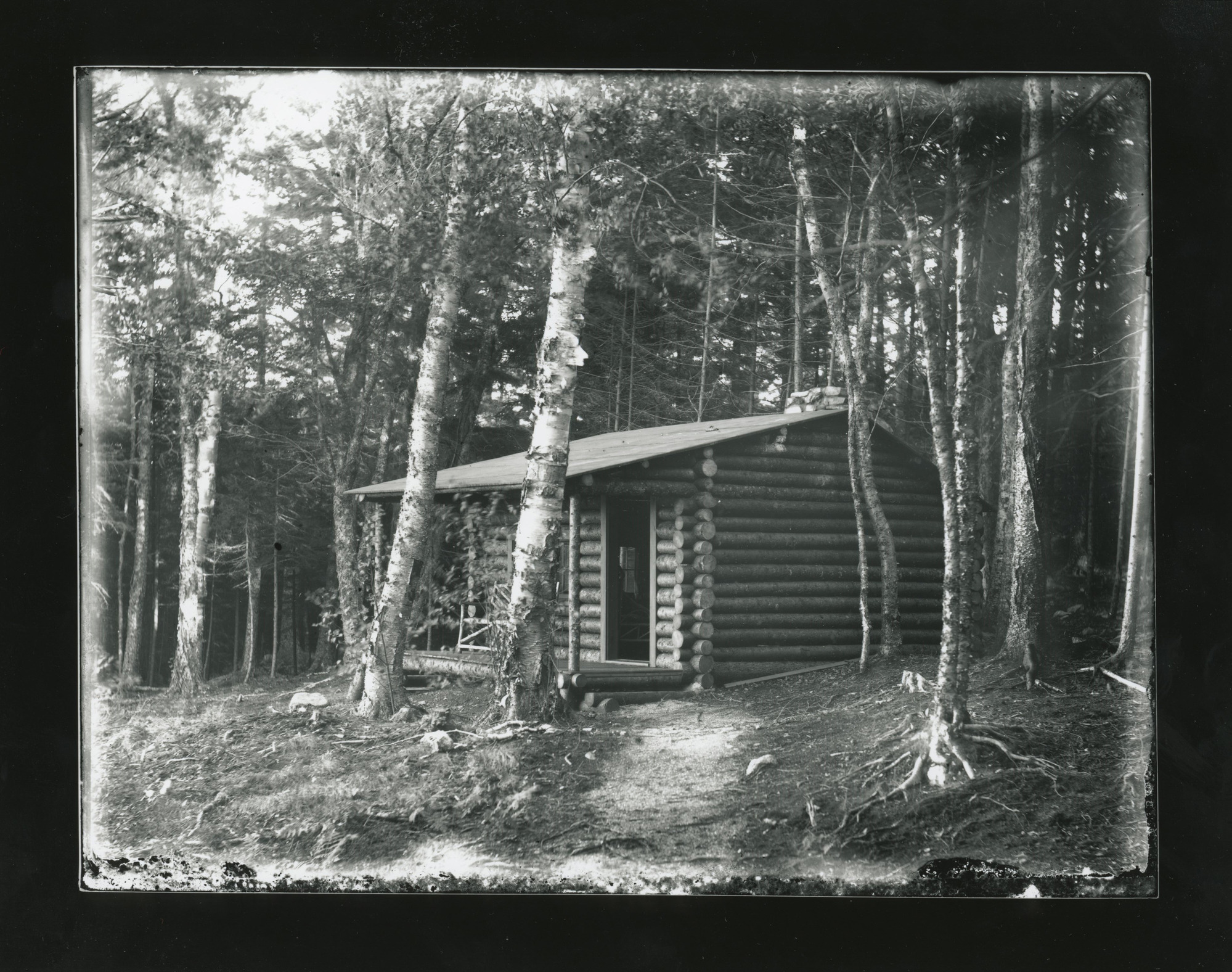Log cabin surrounded by trees.