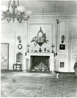 Black and white photograph of fireplace in large 19th century library.