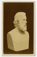 Photograph of a bust of a bearded Longfellow in marble. The view shows Longfellow's face in profile. Only the face and hair are carved in detail.