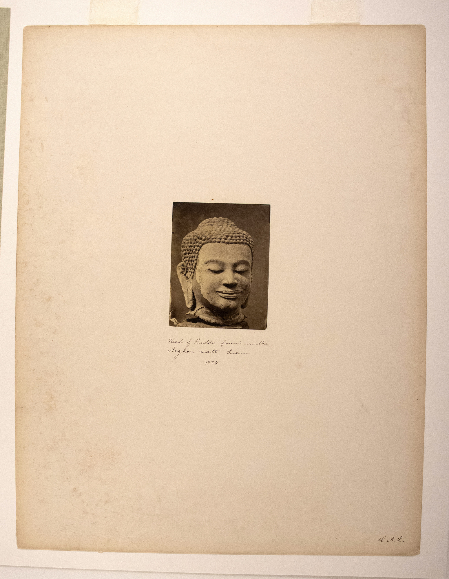 Sepia photograph with an inscription representing the head of a Buddha sculpture.