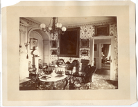 Black and white photograph of elaborately decorated 19th century parlor.