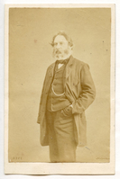 A bearded Henry Wadsworth Longfellow stands at three-quarter view turned toward his right with his left hand in his pocket. His coat is open, and a chain across his vest is prominent. Longfellow's hair is ear-length and his beard is medium-length. He is wearing formal attire.